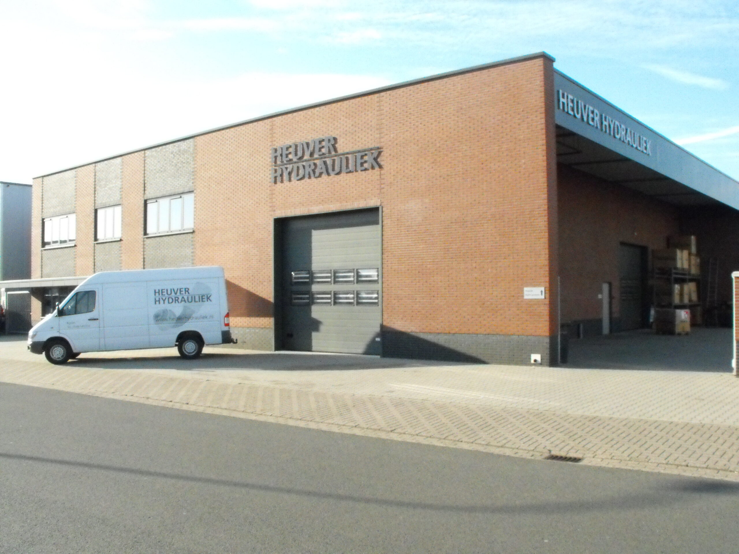 Voorgevel van Heuver Hydrauliek Rijssen met servicebus voor het pand aan de Ethaanstraat in Rijssen