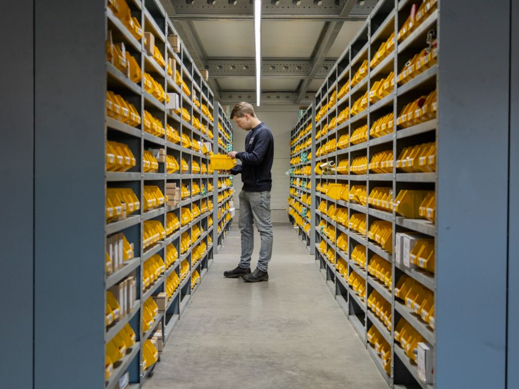 Heuver Hydrauliek magazijnmedewerker pickt hydrauliek onderdelen uit het schappenmagazijn voor snelle levering.