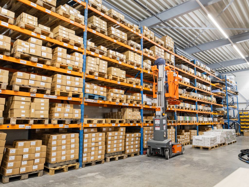 Groot magazijn van Heuver Hydrauliek met hoge stellingen vol hydrauliek onderdelen en intern transportmaterieel voor snelle levering.