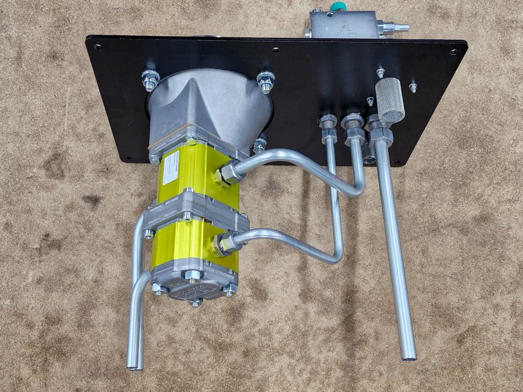Hydraulische pompunit met stalen leidingwerk en koppelingen, op montageplaat opgebouwd door Heuver Hydrauliek.