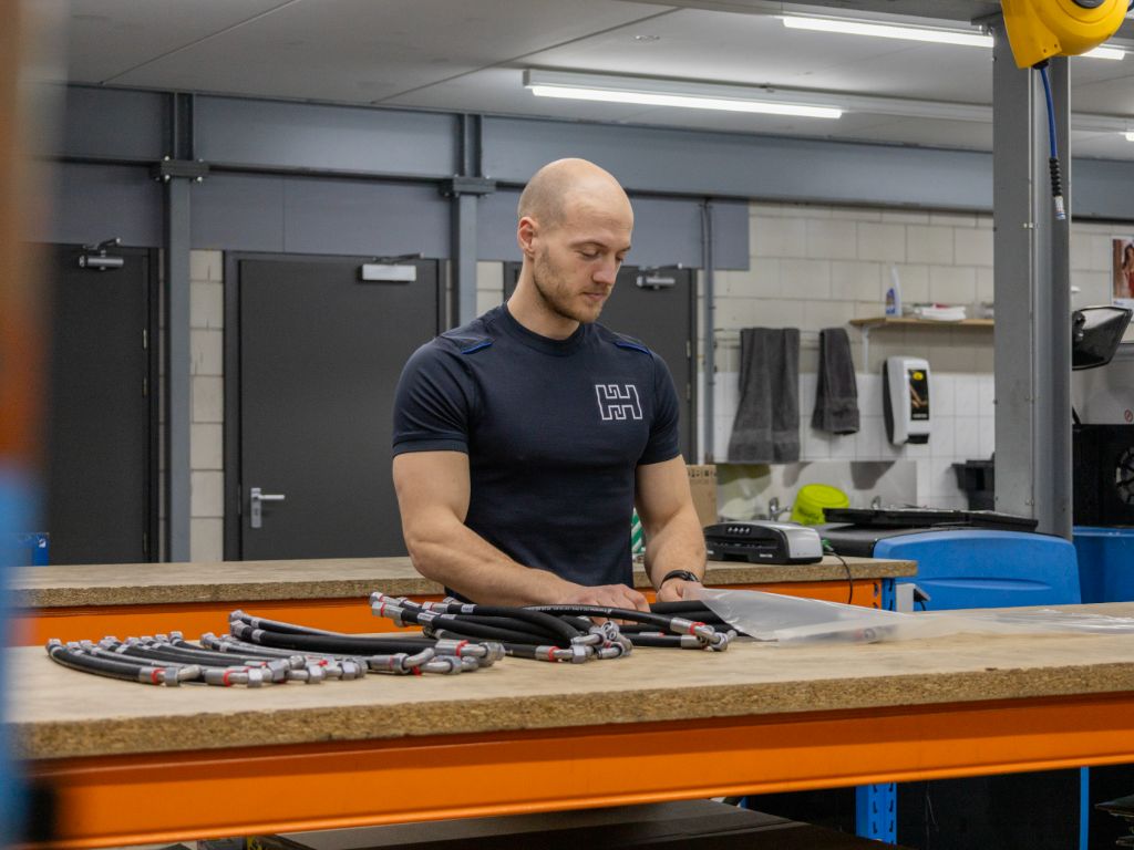 Heuver Hydrauliek medewerker verpakt hydraulische slangassemblages met koppelingen voor veilige verzending.