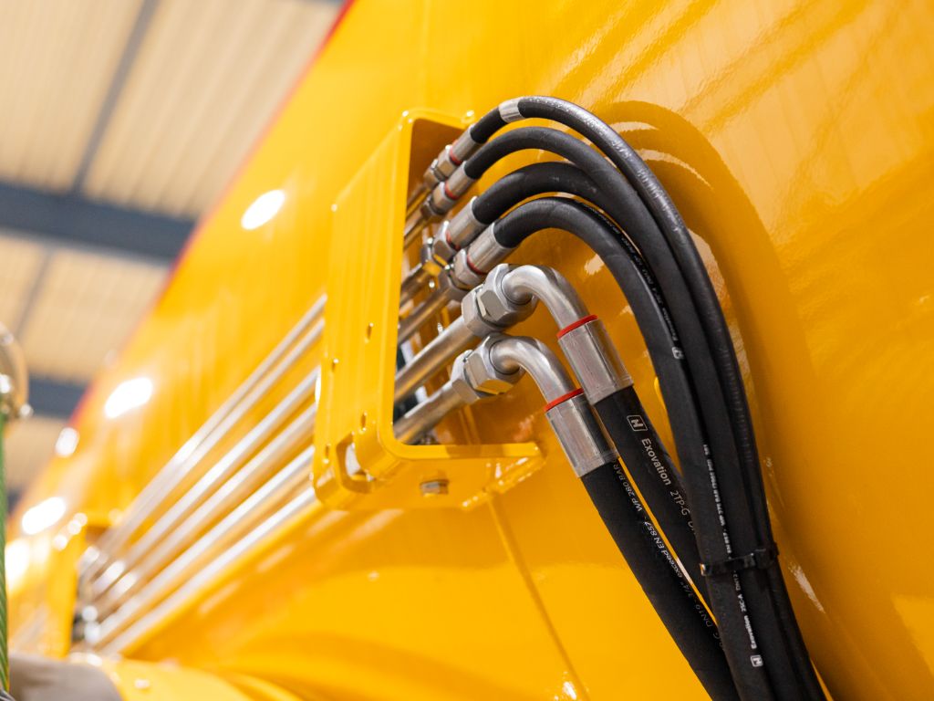 Hydrauliekleidingen en koppelingen netjes aangesloten op een industriële machine, gemonteerd door Heuver Hydrauliek.